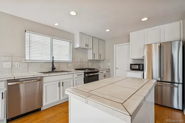 a kitchen with a white cabinets and stainless steel appliances