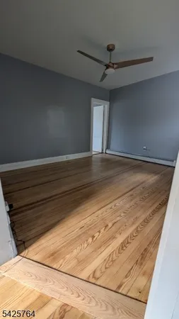 a view of a room with wooden floor and chandelier