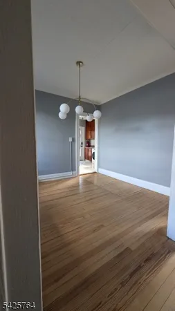 a view of a room with wooden floor and a window