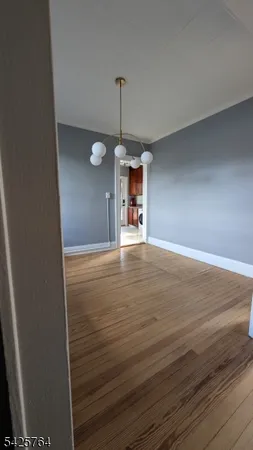 a view of empty room with window and wooden floor