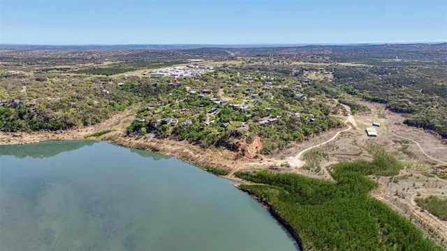 an aerial view of a houses with a yard and lake view
