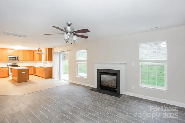 an empty room with windows and a fireplace