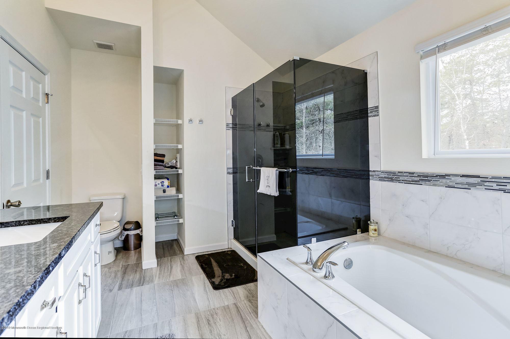 20 Pasadena Road Whiting, NJ 08759 - Photo 38 of 60 a bathroom with a tub sink and a mirror