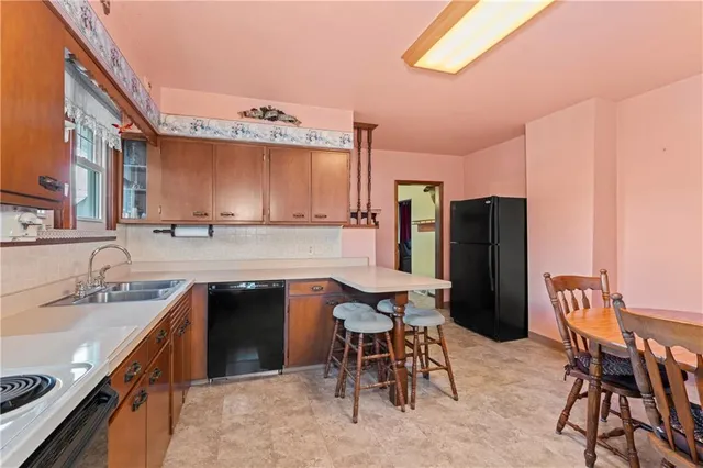 a kitchen with a table chairs sink refrigerator and cabinets