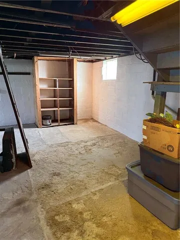 a view of an empty room with wooden floor and windows