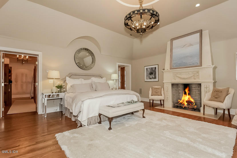 200 Stanwich Road Greenwich, CT 06830 - Photo 13 of 18 a bedroom with a bed and a chandelier