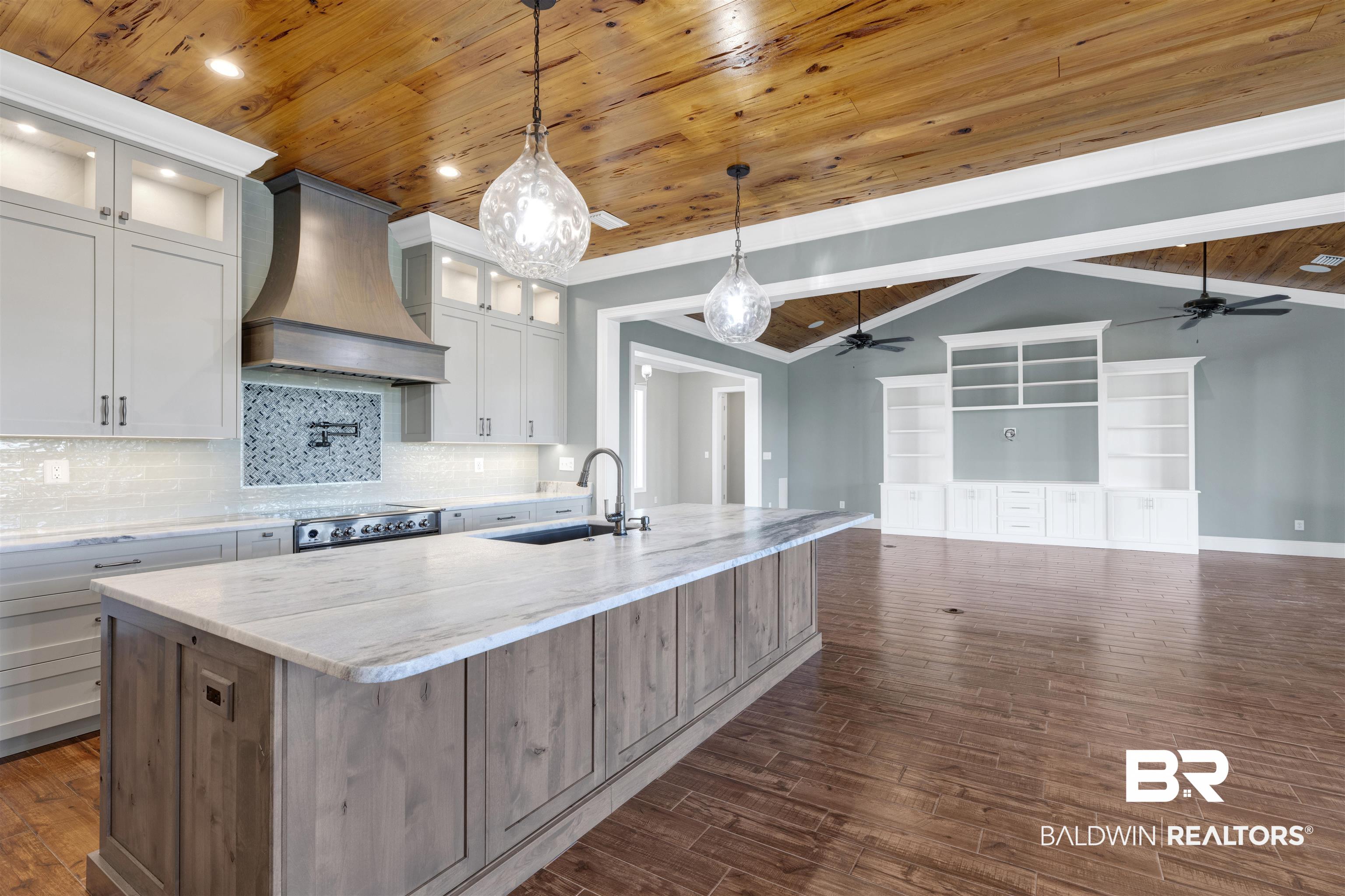 31729 River Road Orange Beach, AL 36561 - Photo 18 of 54 Kitchen with wooden ceiling, dark wood finished floors, light stone counters, hanging light fixtures, and a large island