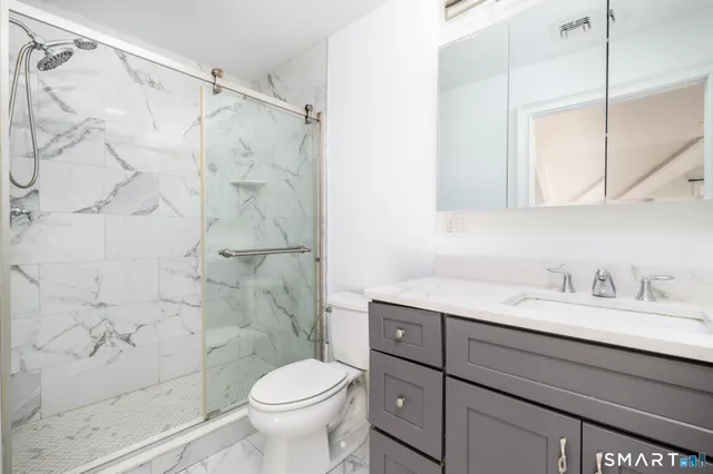 a bathroom with a sink toilet and shower
