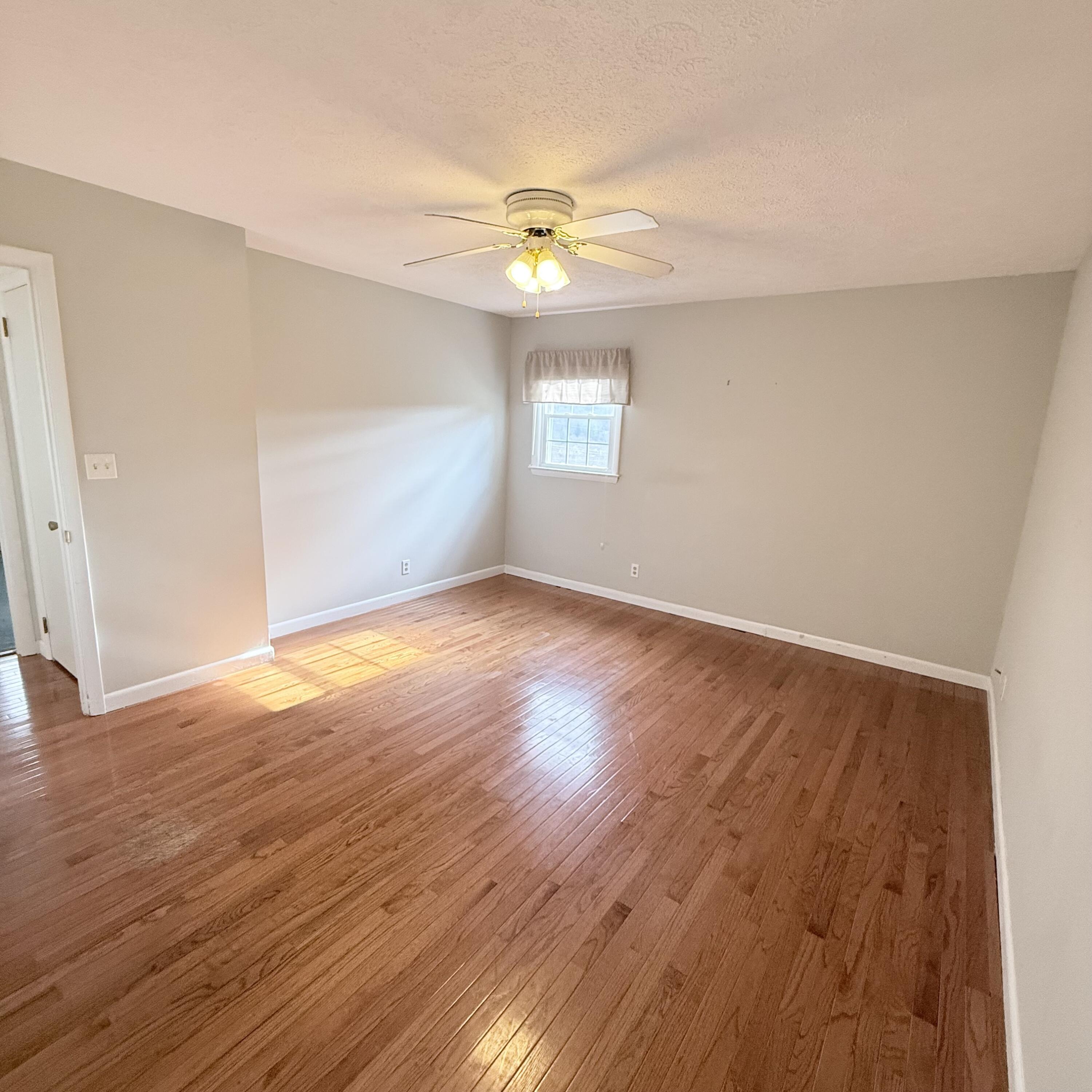 448 Baughman Avenue Marion, VA 24354 - Photo 26 of 43 an empty room with wooden floor chandelier fan and windows