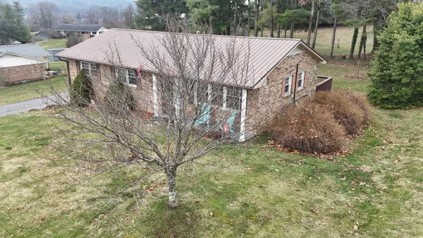 a aerial view of a house with a yard and large trees