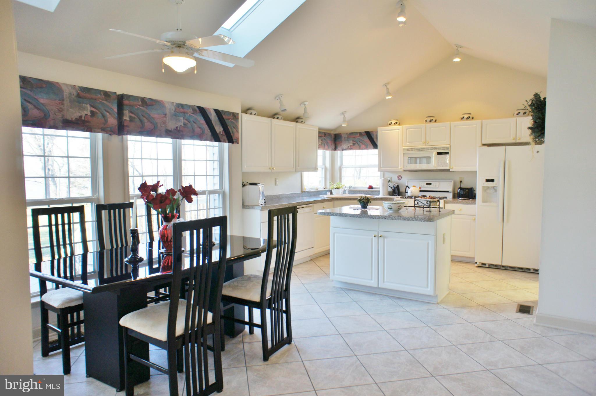 5971 Ketch Road Prince Frederick, MD 20678 - Photo 9 of 30 a kitchen with stainless steel appliances kitchen island granite countertop a table chairs sink and cabinets