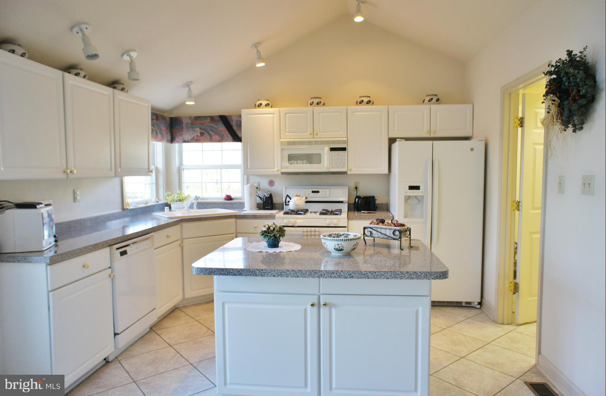 5971 Ketch Road Prince Frederick, MD 20678 - Photo 10 of 30 a kitchen with granite countertop a refrigerator a sink and white cabinets