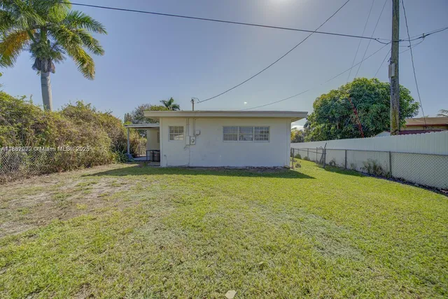 a front view of house with yard and trees around