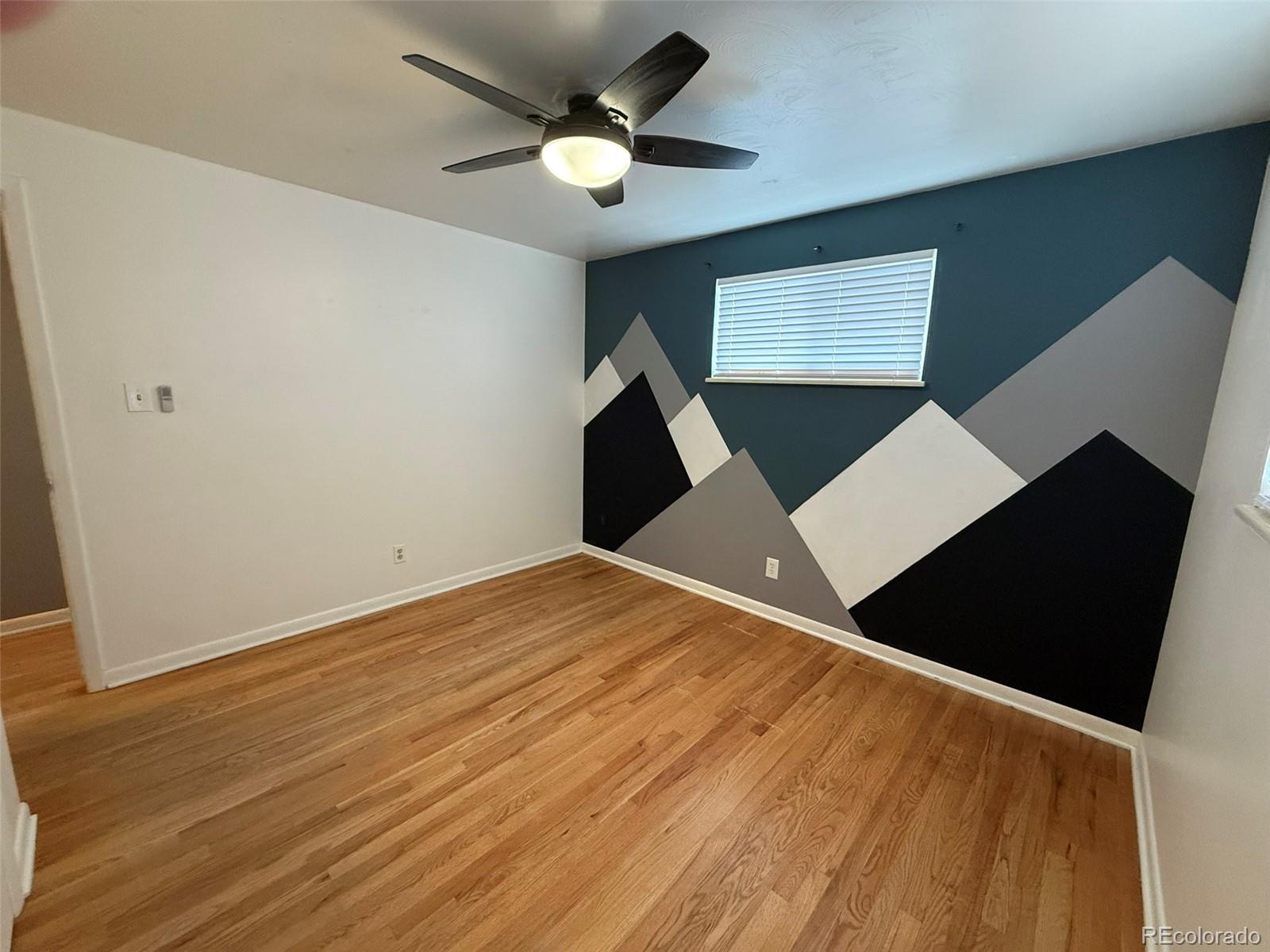 378 South Racine Street Aurora, CO 80012 - Photo 13 of 44 a view of an empty room with wooden floor