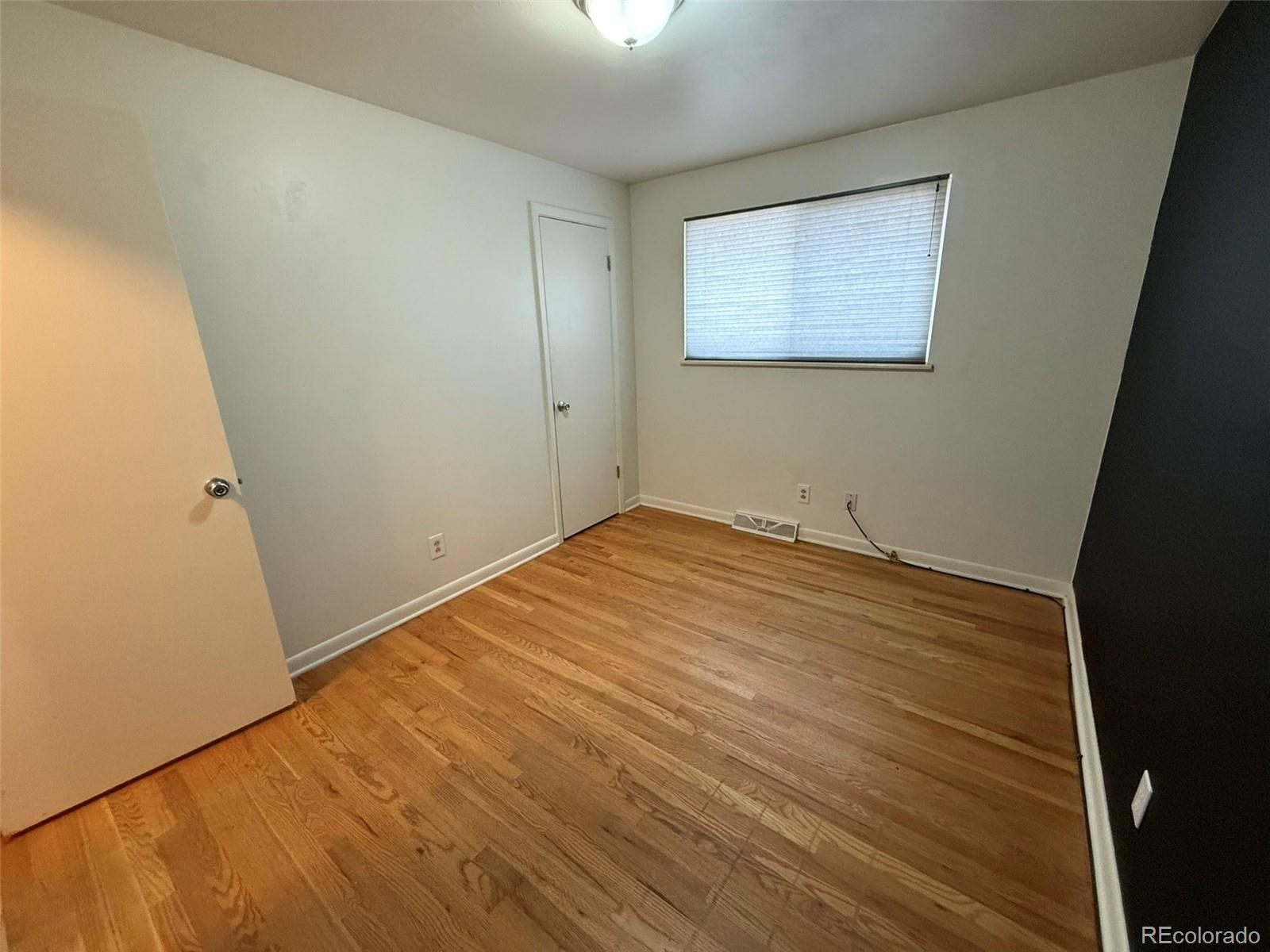 378 South Racine Street Aurora, CO 80012 - Photo 14 of 44 an empty room with wooden floor and windows
