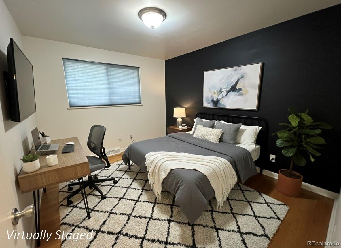 378 South Racine Street Aurora, CO 80012 - Photo 16 of 44 a bedroom with a bed and a flat screen tv