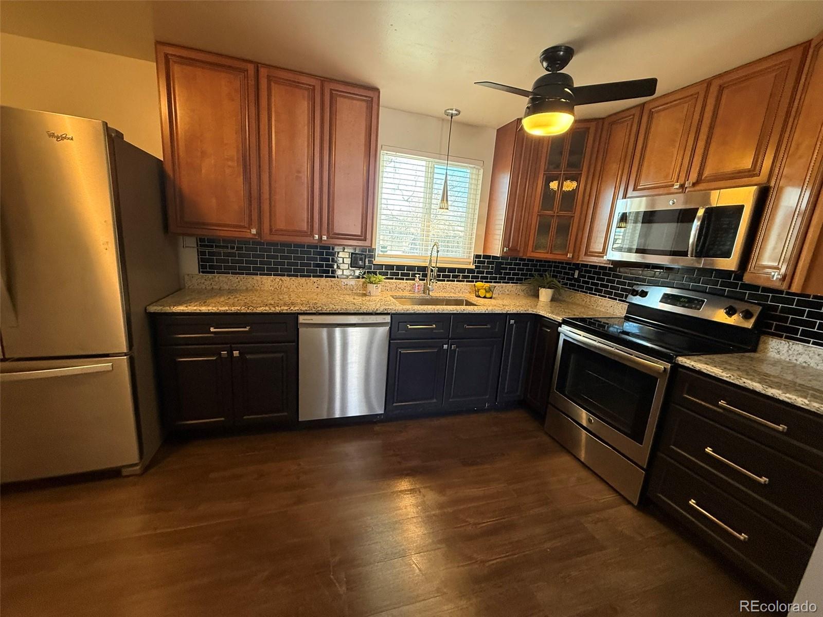 378 South Racine Street Aurora, CO 80012 - Photo 2 of 44 a kitchen with stainless steel appliances granite countertop a stove a sink dishwasher a refrigerator and a microwave