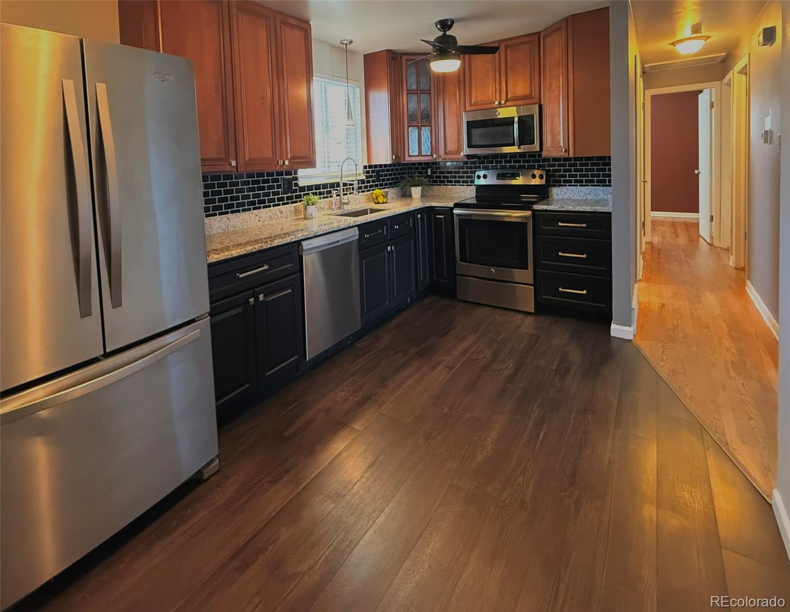 378 South Racine Street Aurora, CO 80012 - Photo 6 of 44 a kitchen with stainless steel appliances granite countertop a refrigerator a stove and a wooden floors