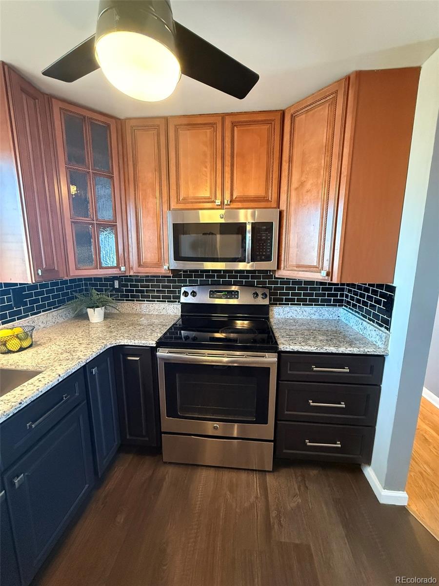 378 South Racine Street Aurora, CO 80012 - Photo 9 of 44 a kitchen with wooden cabinets and a stove top oven