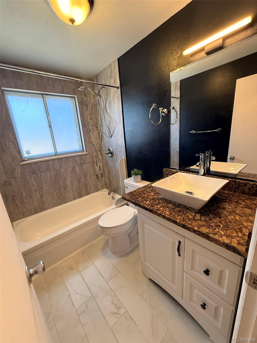 378 South Racine Street Aurora, CO 80012 - Photo 10 of 44 a bathroom with a granite countertop sink a mirror and bathtub