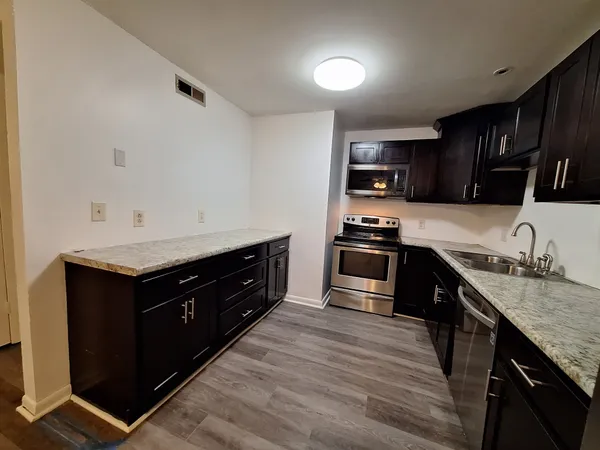 a kitchen with granite countertop a sink and cabinets