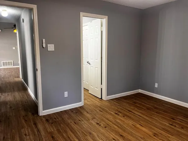an empty room with wooden floor and entrance