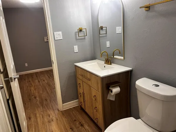 a bathroom with a sink a toilet a mirror and shower