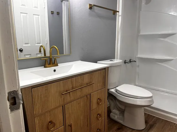 a bathroom with a sink toilet and a mirror