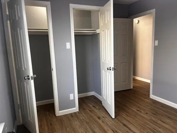 an empty room with wooden floor and closet
