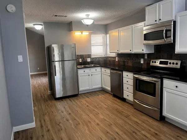 a kitchen with stainless steel appliances kitchen island granite countertop a stove a refrigerator and a microwave