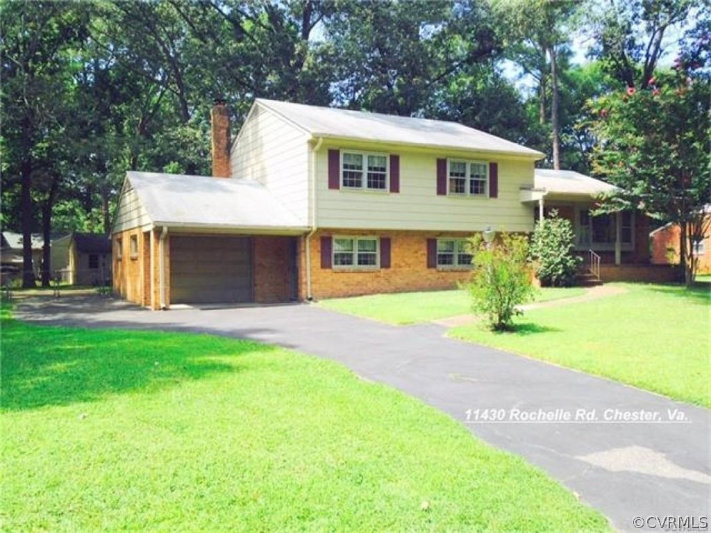 11430 Rochelle Road Chester, VA 23831 - Photo 1 of 21 a front view of a house with a garden and yard