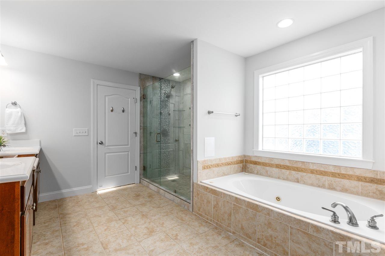6325 Southern Charm Lane Raleigh, NC 27603 - Photo 16 of 29 Garden jacuzzi tub and large, tile walk-in shower.