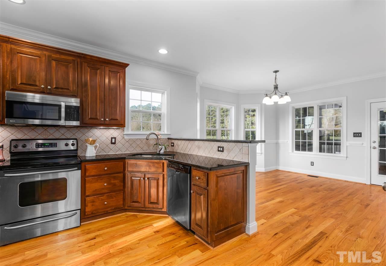 6325 Southern Charm Lane Raleigh, NC 27603 - Photo 7 of 29 Kitchen features stainless steel appliances, granite countertops and tile backsplash.
