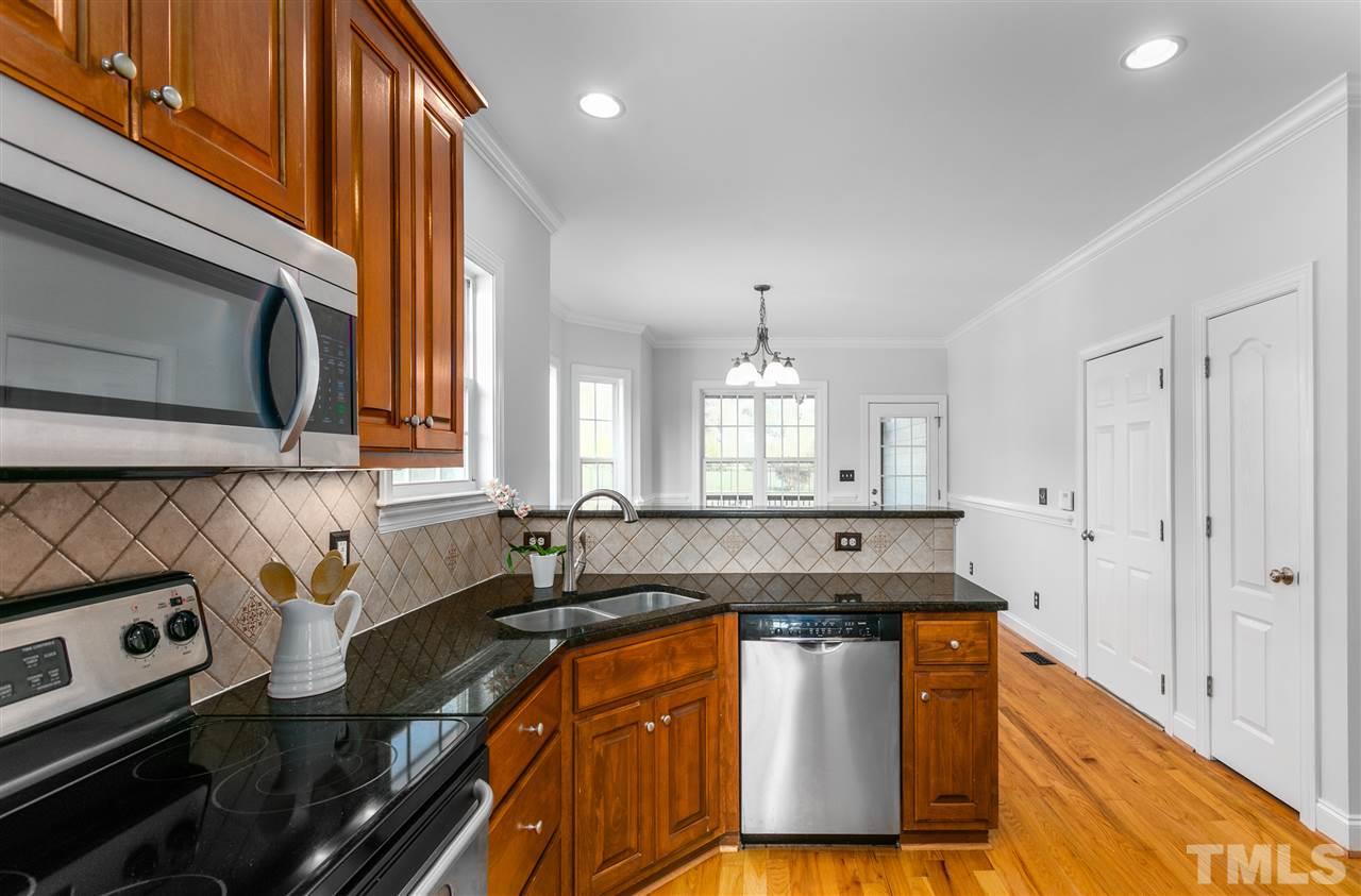6325 Southern Charm Lane Raleigh, NC 27603 - Photo 8 of 29 Kitchen features stainless steel appliances, granite countertops and tile backsplash.