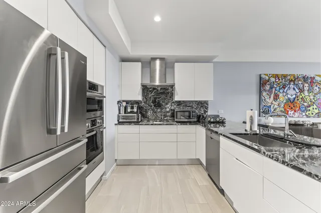 a kitchen with stainless steel appliances granite countertop a refrigerator and a stove
