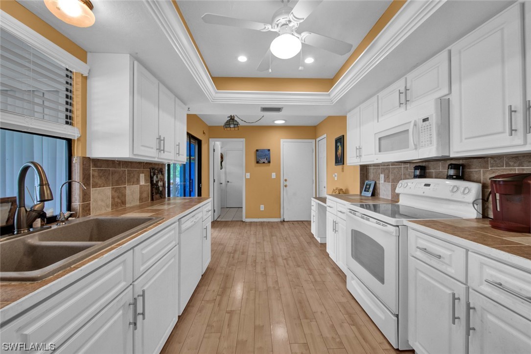 7234 Myrtle Road Fort Myers, FL 33967 - Photo 7 of 32 a large kitchen with stainless steel appliances lots of counter space and wooden floor