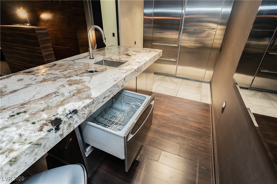 4381 West Flamingo Road, Unit 53321 Las Vegas, NV 89103 - Photo 11 of 41 Kitchen with light stone counters, high end refrigerator, light wood finished floors, and a breakfast bar area