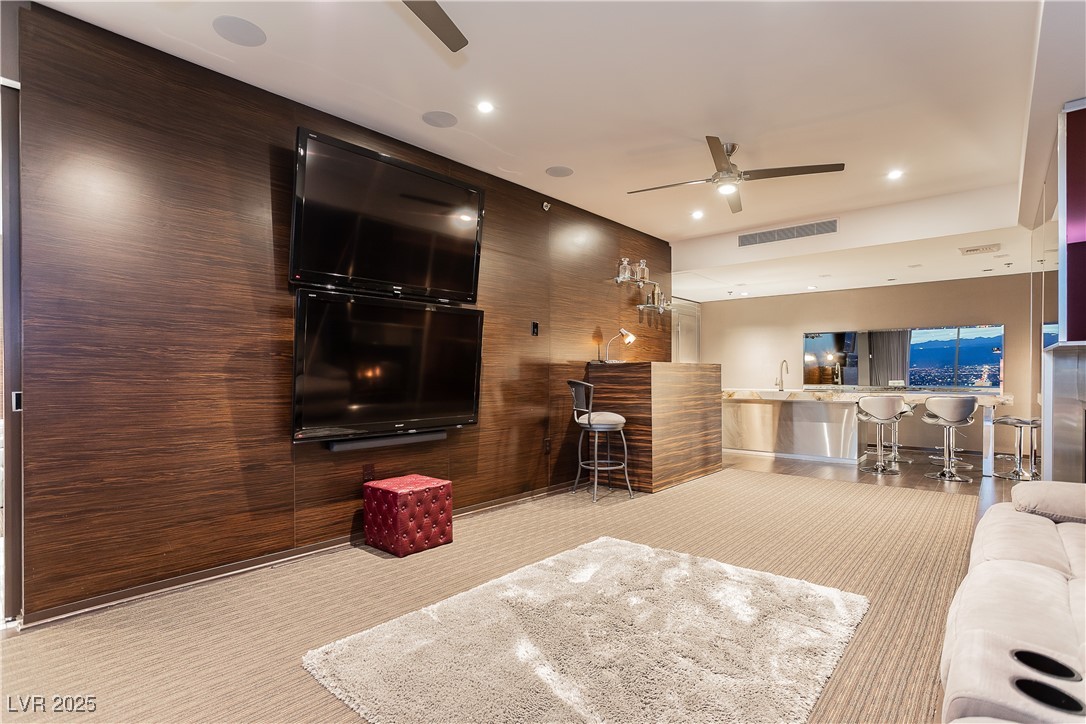 4381 West Flamingo Road, Unit 53321 Las Vegas, NV 89103 - Photo 15 of 41 Living area featuring light carpet, a ceiling fan, recessed lighting, and wood walls