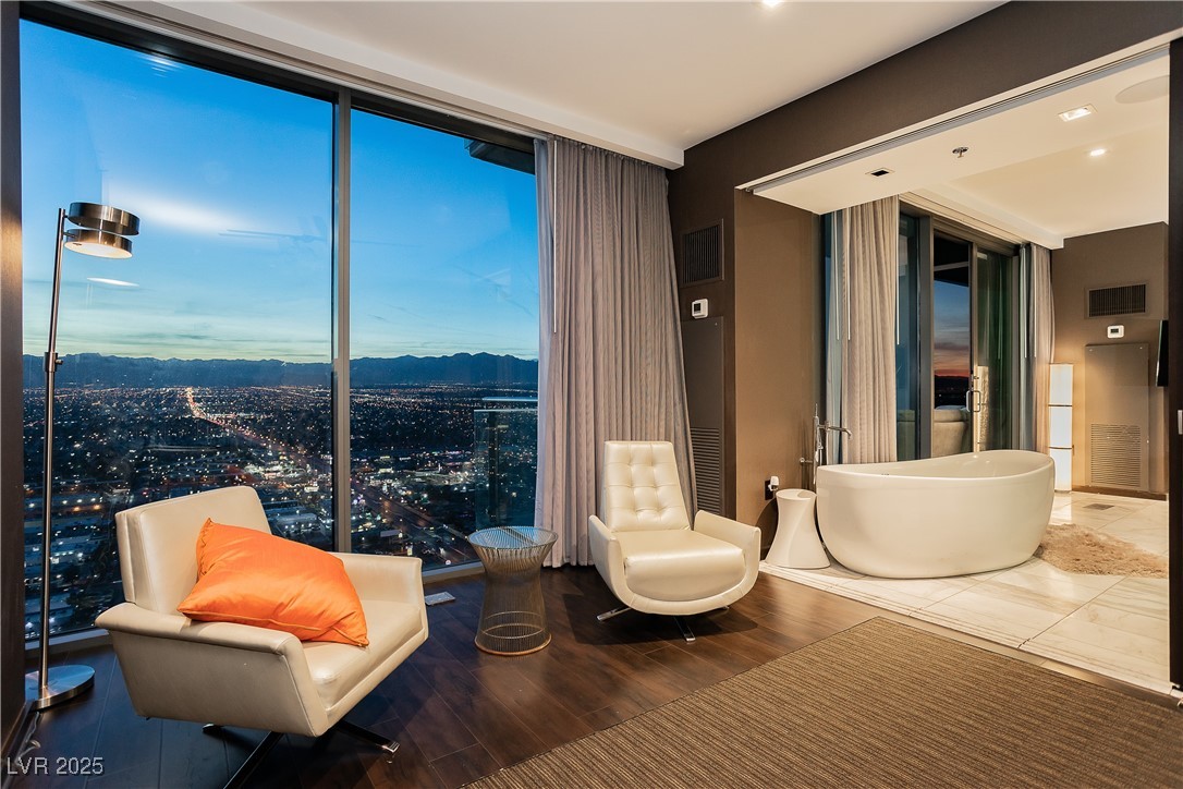 4381 West Flamingo Road, Unit 53321 Las Vegas, NV 89103 - Photo 16 of 41 Living area featuring a city view and wood finished floors