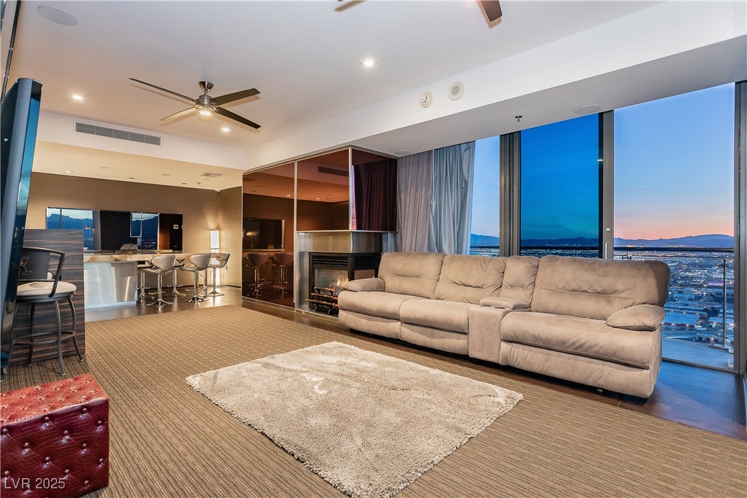 4381 West Flamingo Road, Unit 53321 Las Vegas, NV 89103 - Photo 18 of 41 Carpeted living area featuring ceiling fan, a multi sided fireplace, and recessed lighting