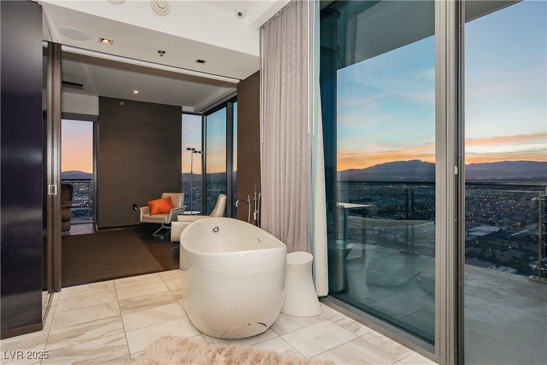 4381 West Flamingo Road, Unit 53321 Las Vegas, NV 89103 - Photo 24 of 41 Bathroom with a freestanding bath, a mountain view, and expansive windows