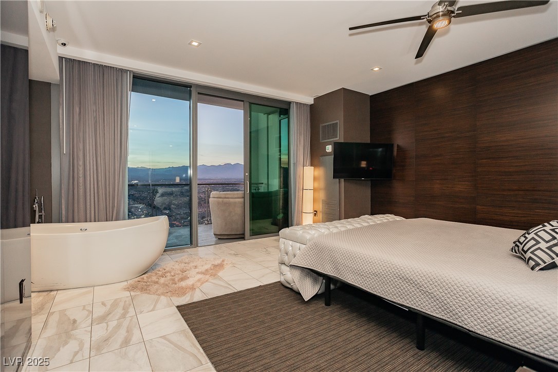 4381 West Flamingo Road, Unit 53321 Las Vegas, NV 89103 - Photo 26 of 41 Bedroom featuring access to exterior, a ceiling fan, expansive windows, wood walls, and recessed lighting
