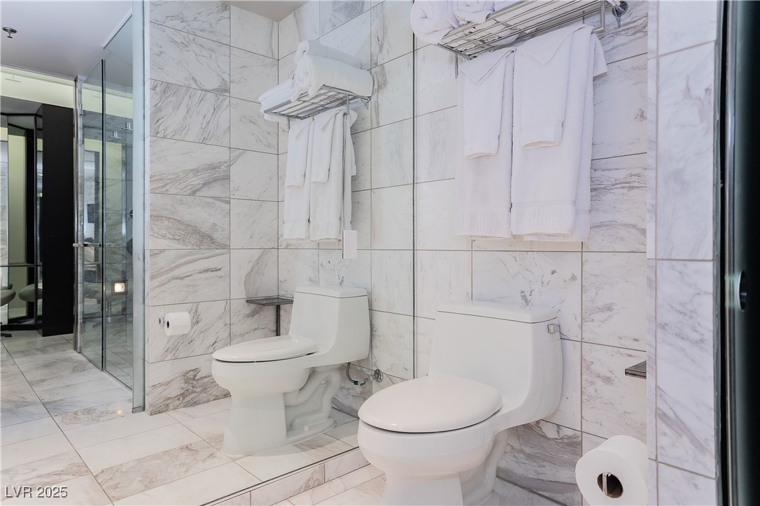 4381 West Flamingo Road, Unit 53321 Las Vegas, NV 89103 - Photo 31 of 41 Bathroom featuring tile walls and marble finish flooring