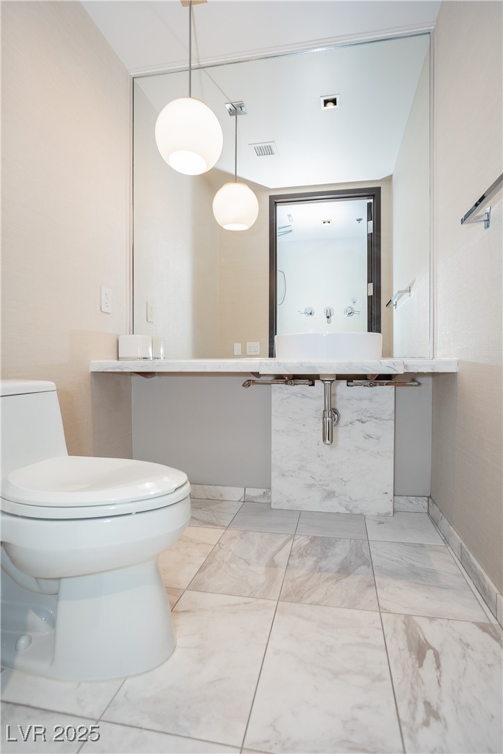4381 West Flamingo Road, Unit 53321 Las Vegas, NV 89103 - Photo 5 of 41 Bathroom with toilet and light marble finish floors