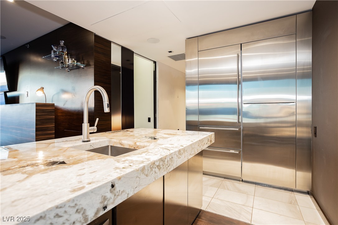 4381 West Flamingo Road, Unit 53321 Las Vegas, NV 89103 - Photo 8 of 41 Kitchen featuring light stone counters and light tile patterned floors