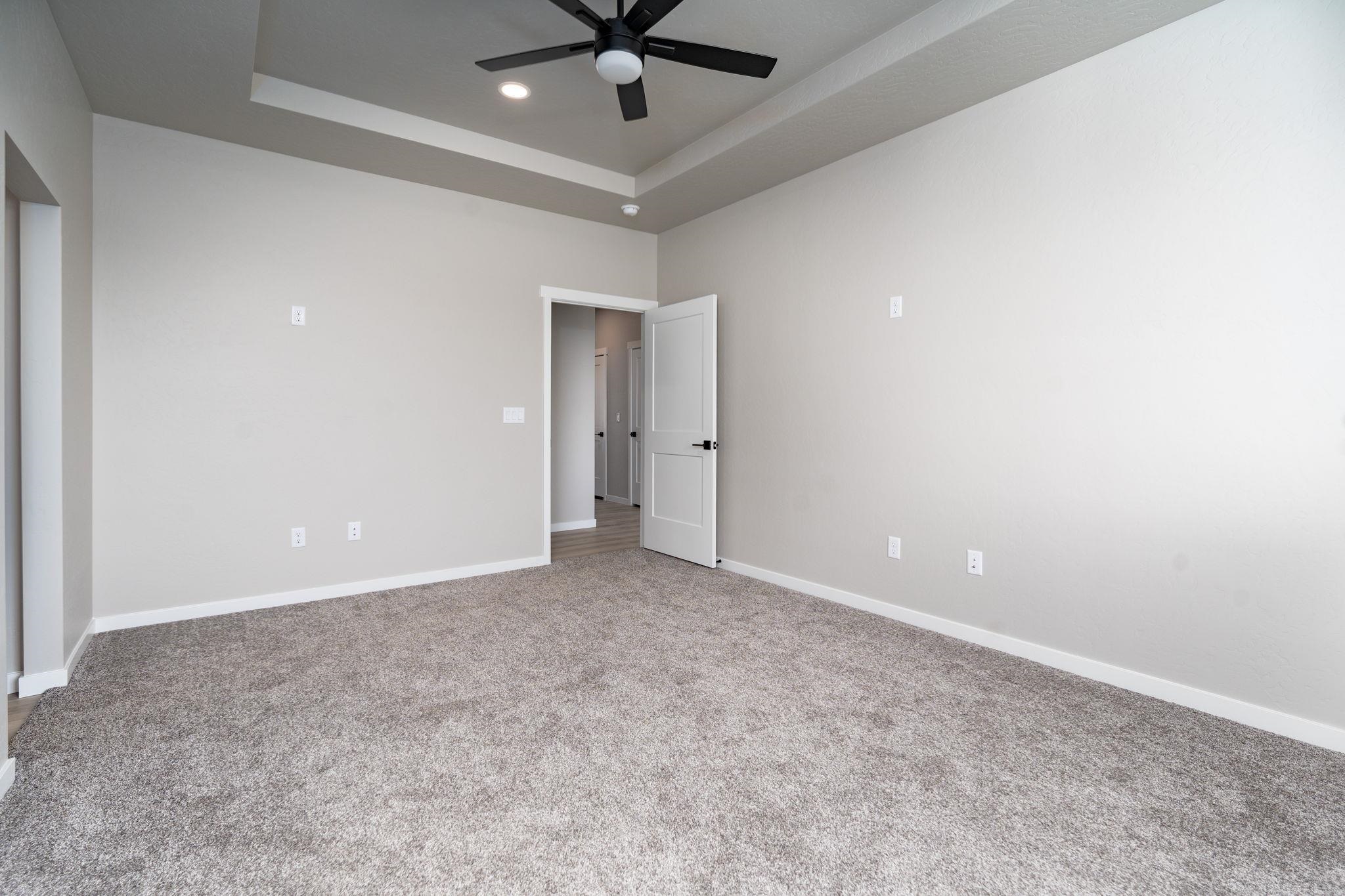 1750 Caliper Way Fruita, CO 81521 - Photo 12 of 19 an empty room with a ceiling fan and carpet