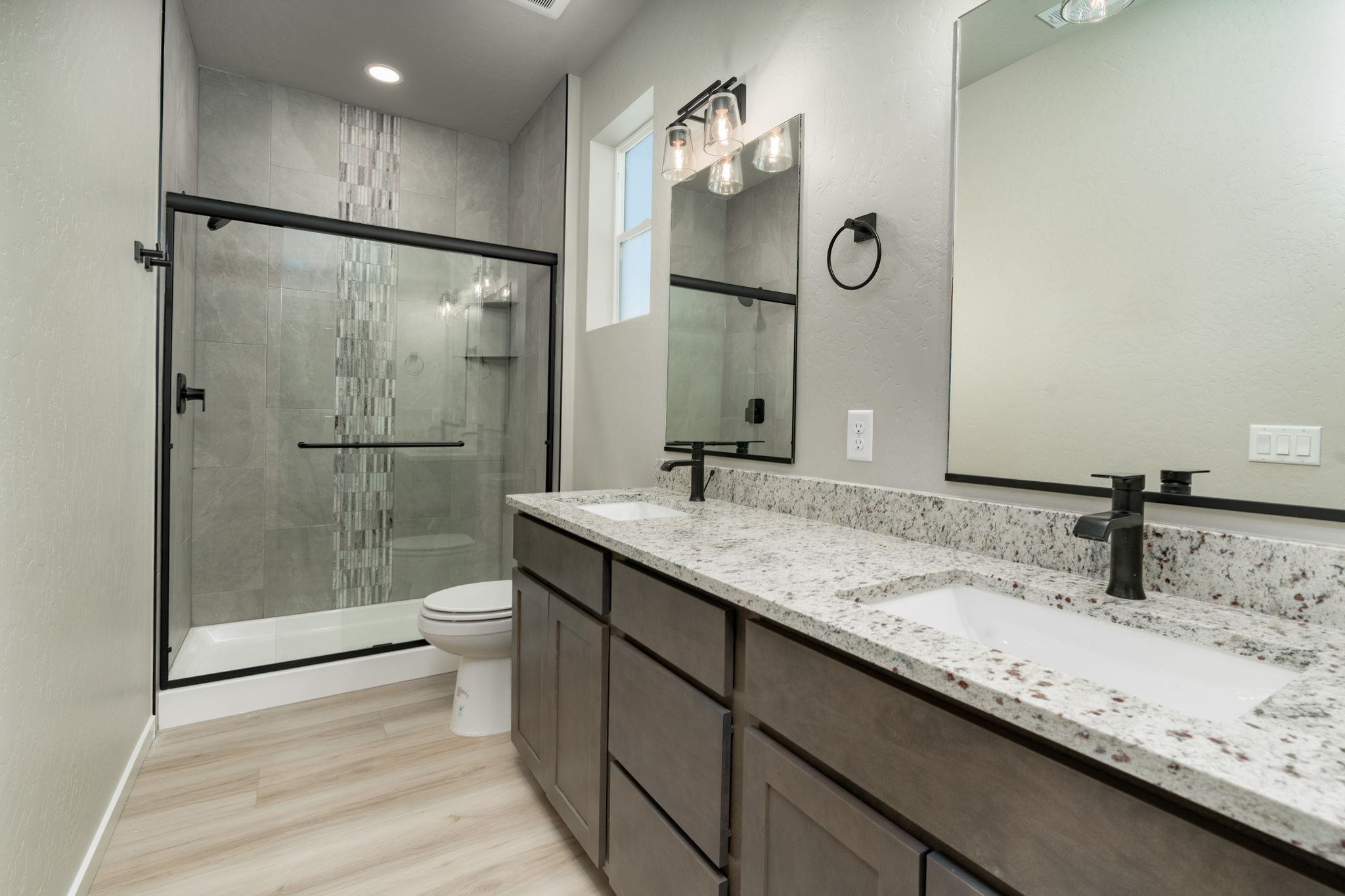 1750 Caliper Way Fruita, CO 81521 - Photo 13 of 19 a bathroom with a granite countertop sink a toilet and shower