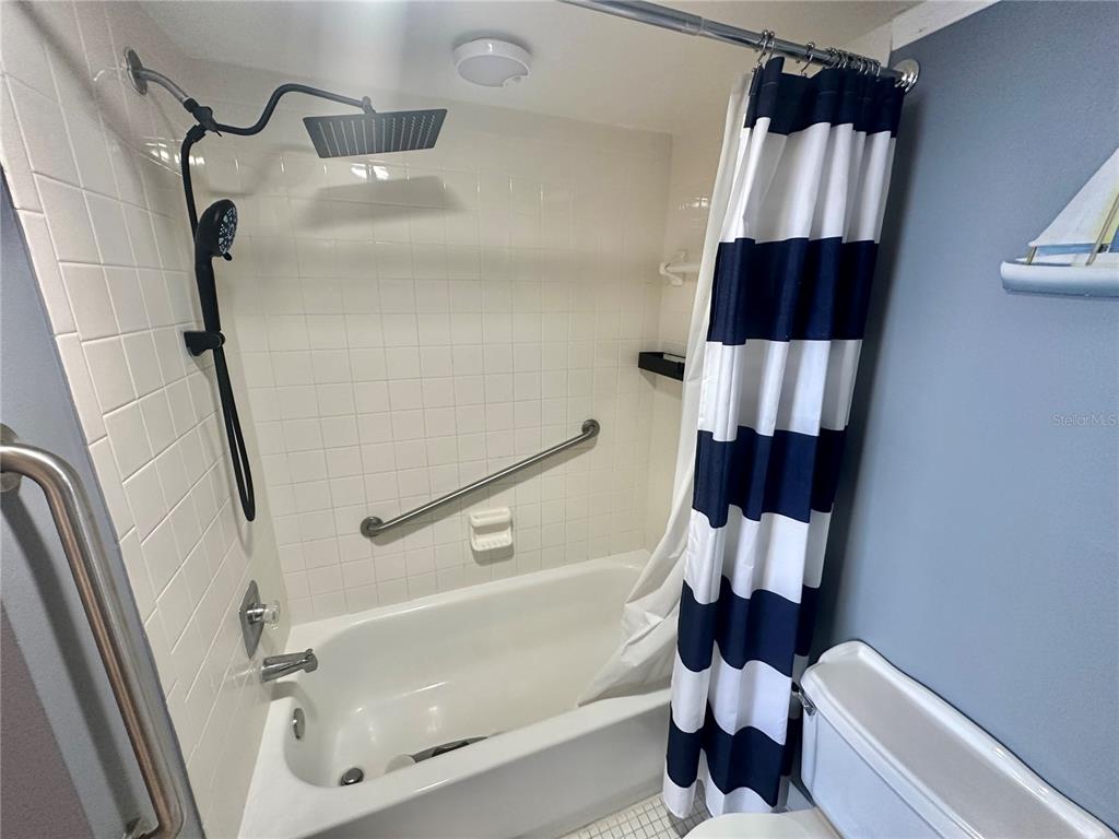 6009 Sea Ranch Drive, Unit 704 Hudson, FL 34667 - Photo 17 of 57 a bathroom with a sink a mirror a bathtub and a shower