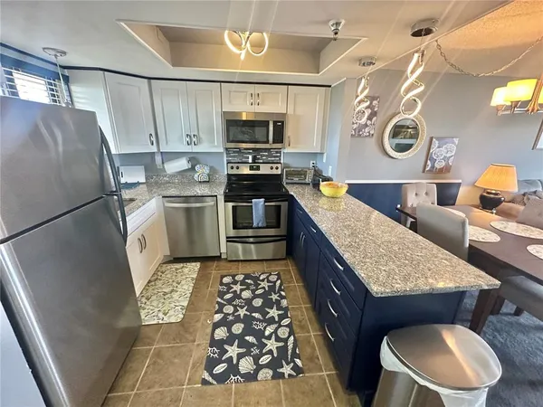 a kitchen with stainless steel appliances granite countertop a refrigerator and a stove