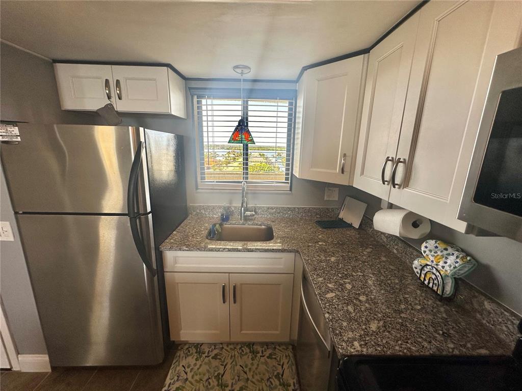 6009 Sea Ranch Drive, Unit 704 Hudson, FL 34667 - Photo 5 of 57 a kitchen with stainless steel appliances granite countertop a refrigerator stove and sink